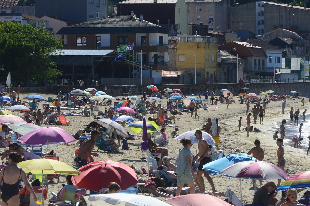 La playa de Banda do Río, en Bueu, este verano con la bandera azul al fondo.