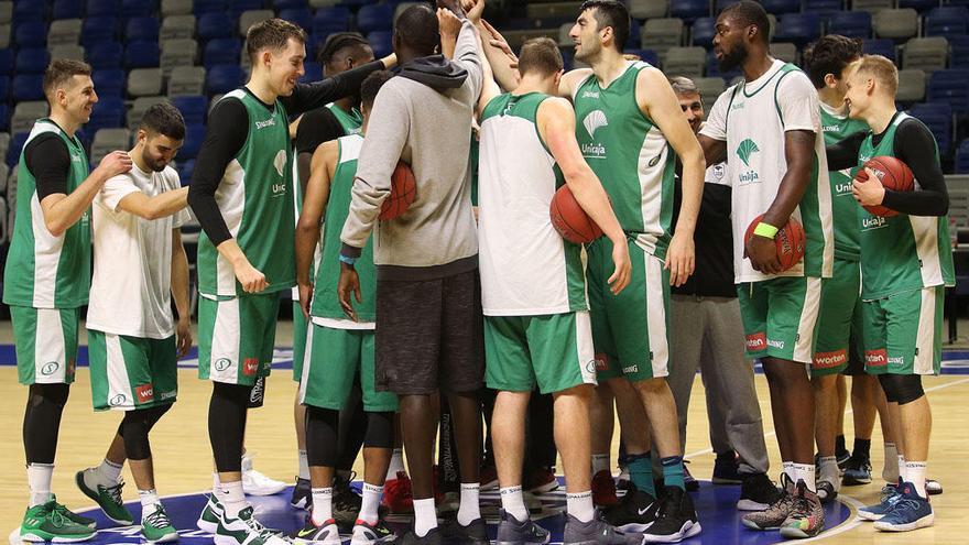 La plantilla del Unicaja, acabando un entrenamiento, saludándose en el centro de la pista.