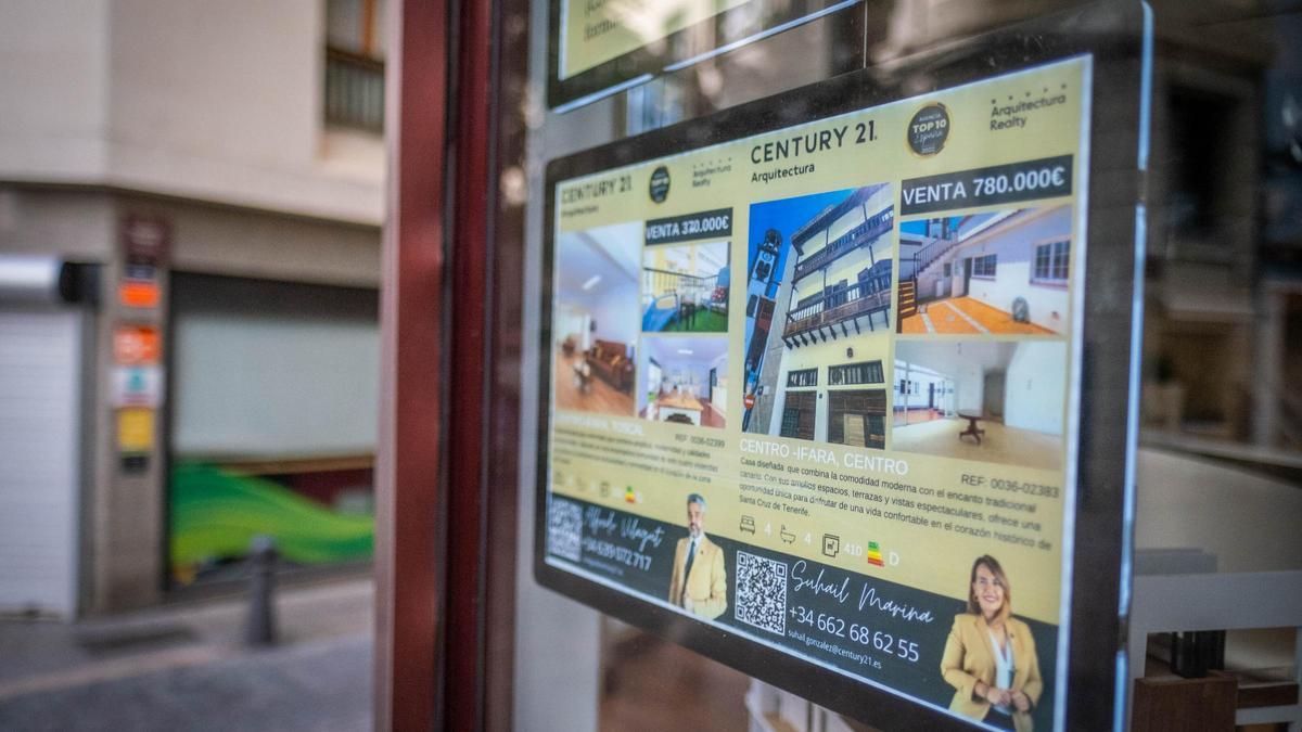 Cartel informativo de viviendas en venta en el escaparate de una agencia inmobiliaria del Archipiélago.