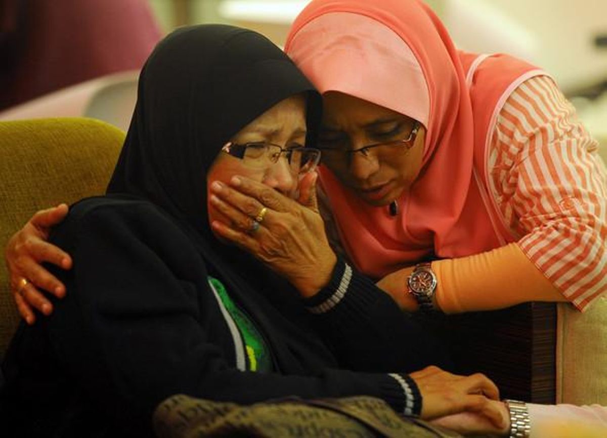 Dues dones, que tenen familiars que viatjaven en el vol de Malaysia Airlines, ploren en un hotel de Putrajaya, a Malàisia.