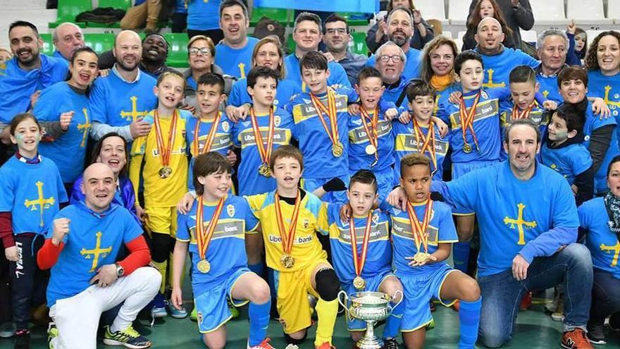 La expedición asturiana, con los doce jugadores en el centro con sus medallas de oro, posa en la cancha tras la final.