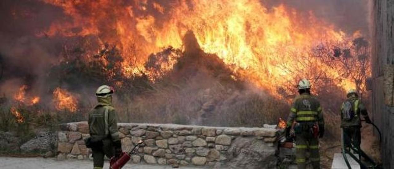 Tres bomberos en una quema controlada en Carnota.  | // EFE/LAVANDEIRA JR.