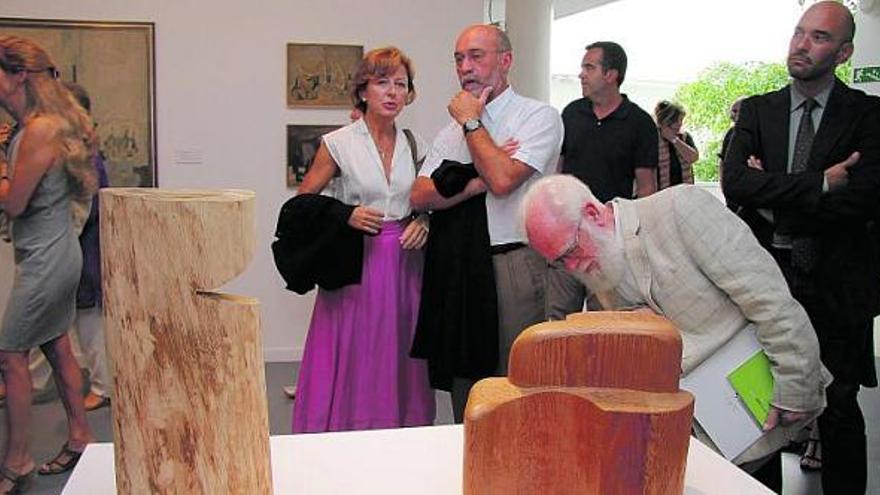 Inauguración de la muestra sobre Joaquín Rubio Camín en el Museo Barjola, en Gijón. En primer término, el hermano del artista contempla algunas de las esculturas en madera de la exposición.