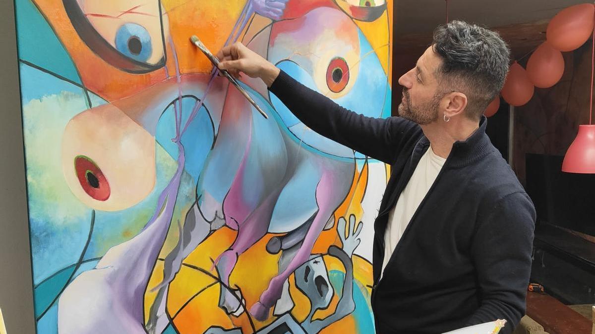 El artista Tachi, con uno de sus cuadros