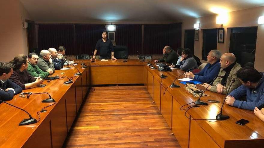 Manuel Ángel Menéndez, en pie, al fondo, se dirige a los políticos y a algunos trabajadores de la central asistentes a la reunión celebrada en el Ayuntamiento de Tineo.