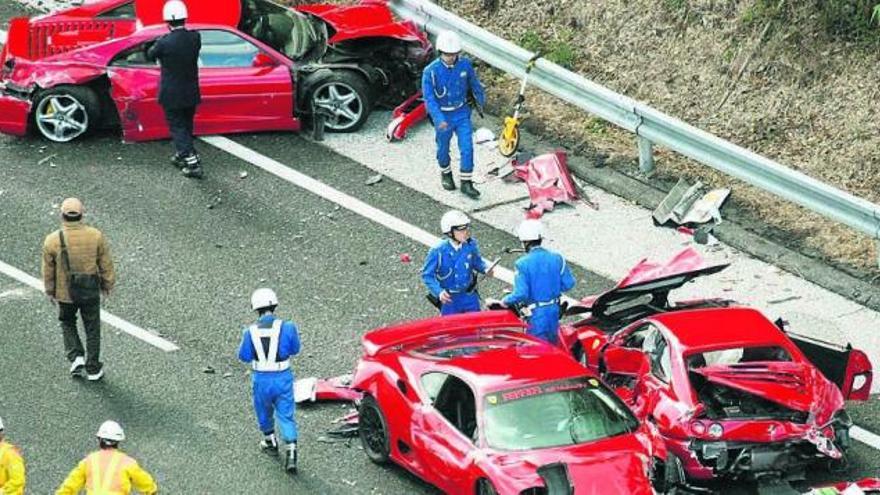 Policías japoneses junto a tres de los 14 vehículos siniestrados ayer en una autovía. / kyodo