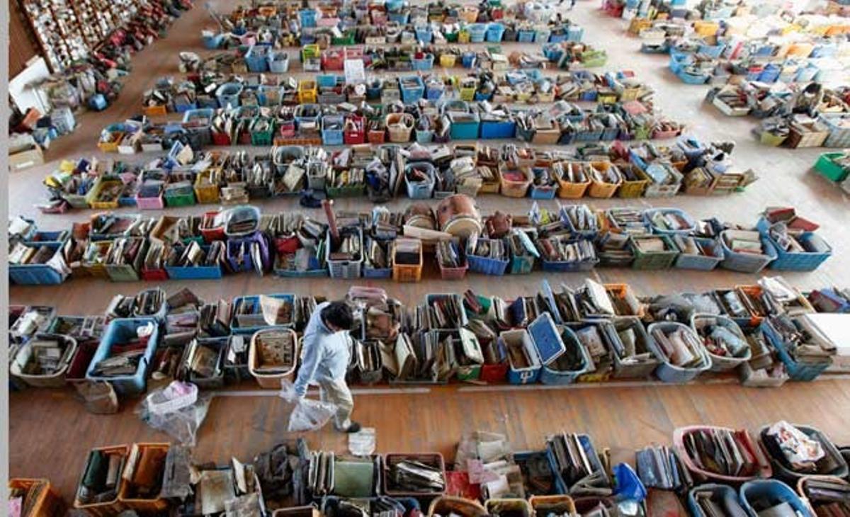 Un home busca les seves pertinences personals en un centre on s’emmagatzemen alguns dels d’objectes trobats a l’àrea devastada pel sisme al Japó.