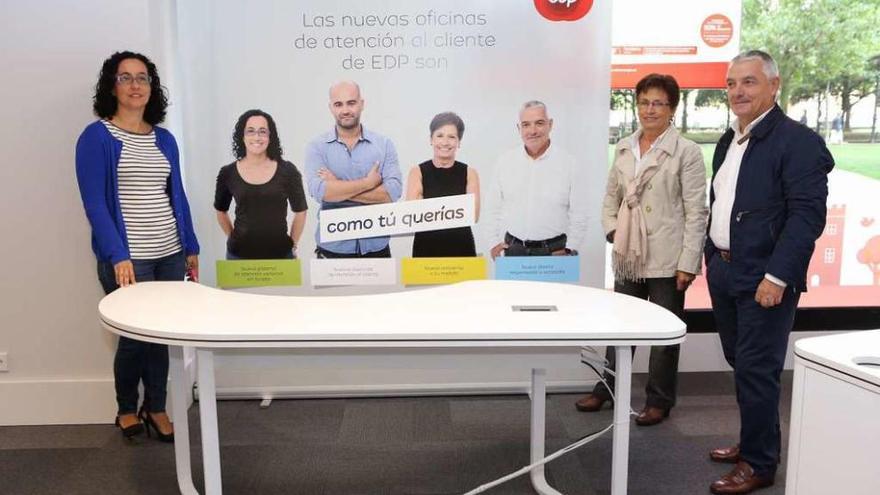 Carmen García, Isabel González y Ciprián Castro, junto al cartel que protagonizan en la campaña de presentación de las nuevas oficinas de atención al cliente de EDP.