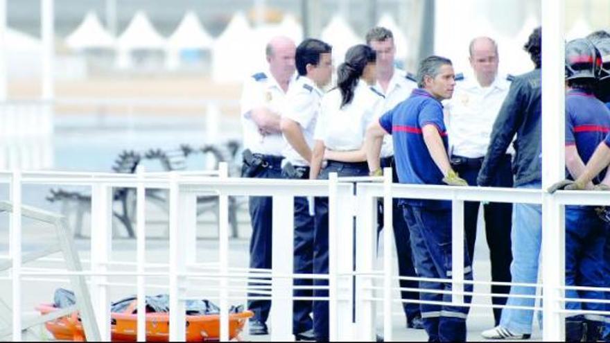 El cadáver, tras ser rescatado del agua, en presencia de varios efectivos de Bomberos y del Cuerpo Nacional de Policía.