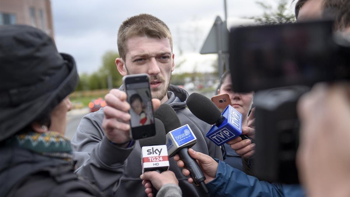 Tom Evans, padre de Alfie, muestra una foto de su hijo a las puertas del hospital donde se encontraba ingresado, este jueves.