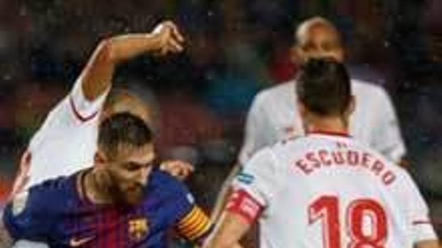Messi trata de llevarse el balón en el partido ante el Sevilla.
