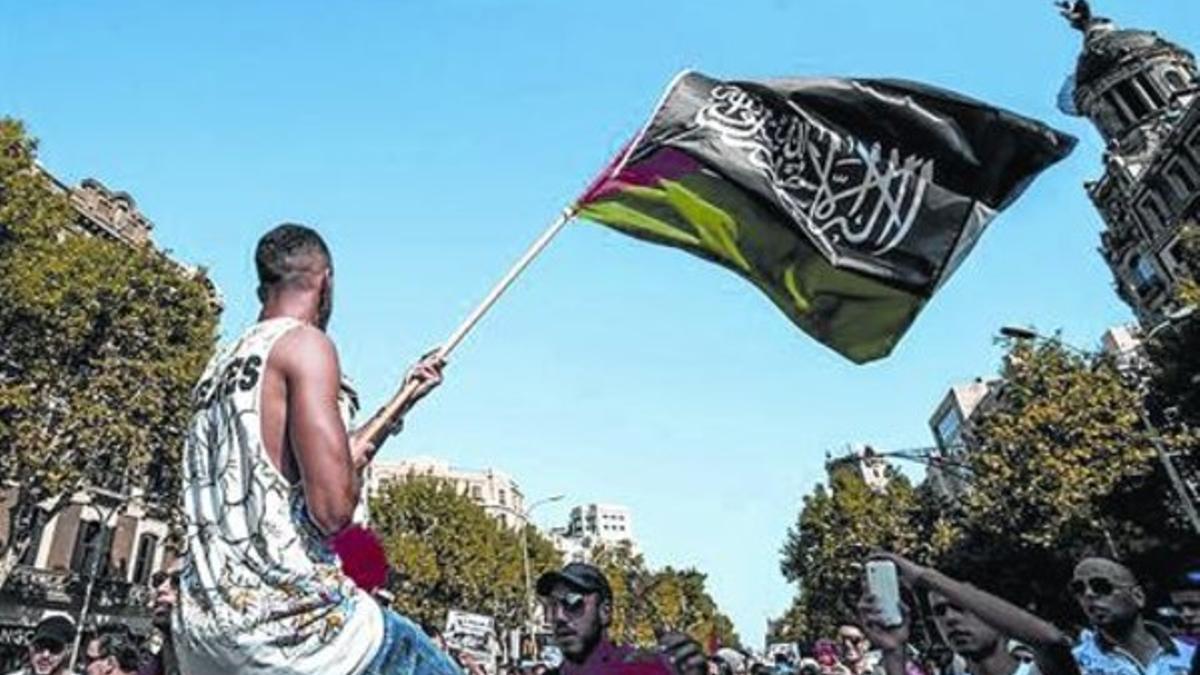 Un joven exhibe una bandera de Al Qaeda en una manifestación en Barcelona, en julio.
