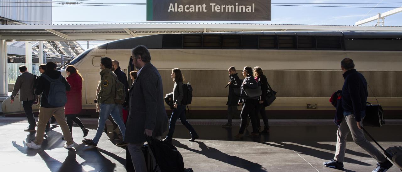 Pasajeros del AVE que conecta Alicante y Madrid dirgiéndose al vestíbulo de la estación tras bajar del tren