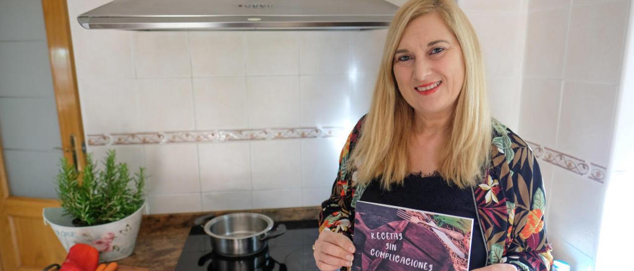 La autora, en la cocina de su casa con el recetario.