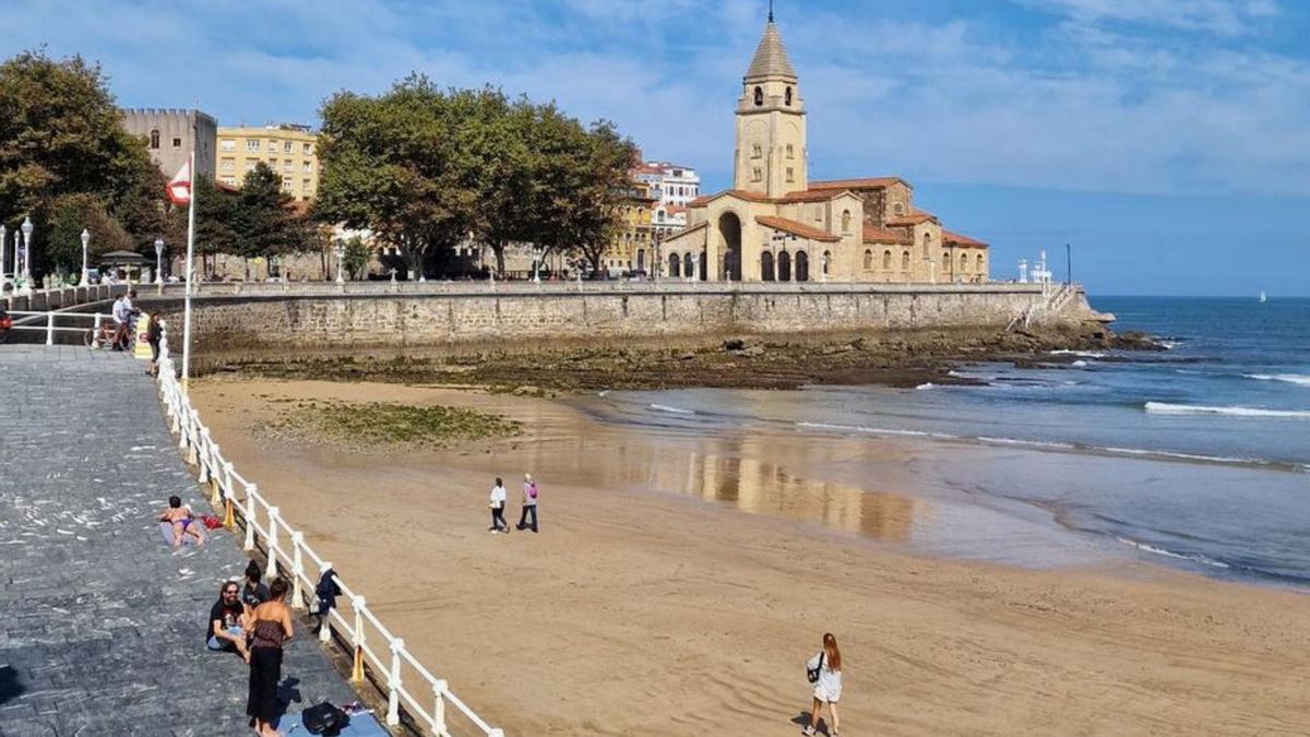 La playa de San Lorenzo y la iglesia de San Pedro, en Gijón, ayer. | R. del Río