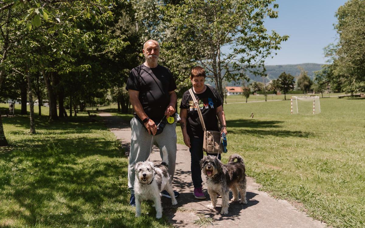 Dos vecinos de Gautegiz Arteaga pasean a sus perros por las infinitas zonas verdes del pueblo.