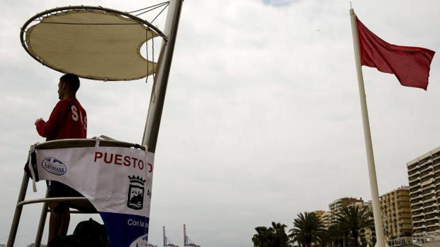 Un socorrista observa la playa de la Malagueta bajo bandera roja por la aparición de una treintena de carabelas portuguesas en el municipio de Vélez-Málaga.