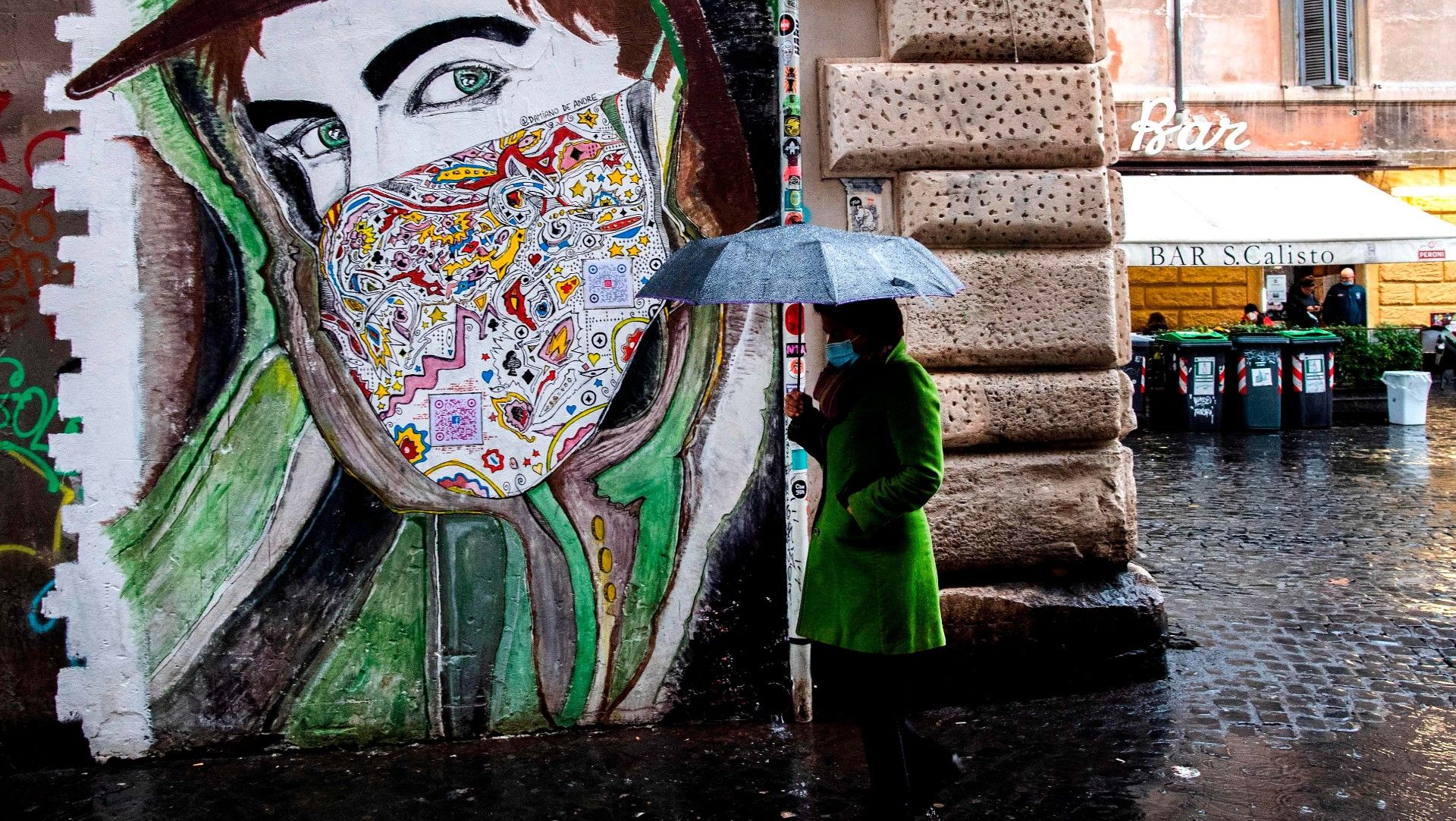 Una mujer pasa frente a un grafiti en el barrio de Trastevere de Roma.