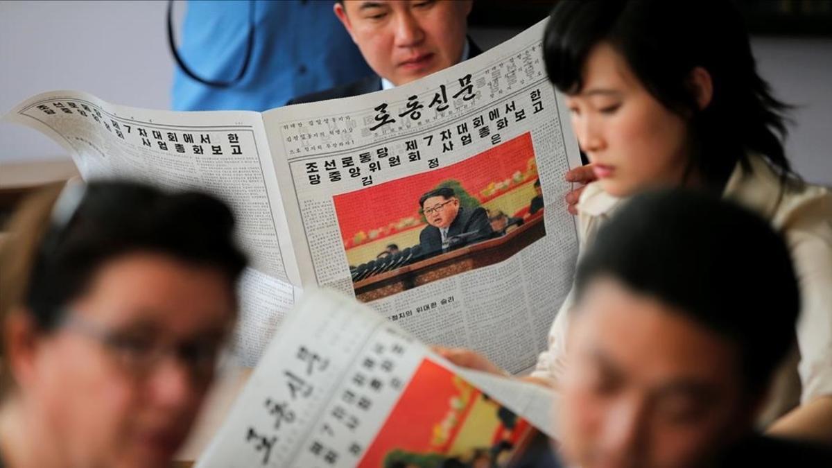 Periodistas extranjeros y sus guías oficiales leen en la prensa el discurso de Kim Jong-un.