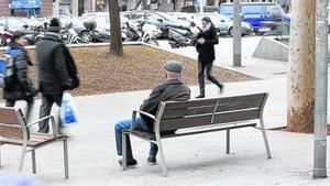 Un avi assegut en un banc de l’avinguda de Roma, ahir.
