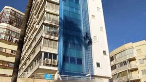 Una dona talla les cordes a un operari que treballava penjat a la façana del seu edifici a Benidorm
