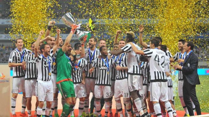 Los futbolistas del Juventus, con el trofeo al final del partido.