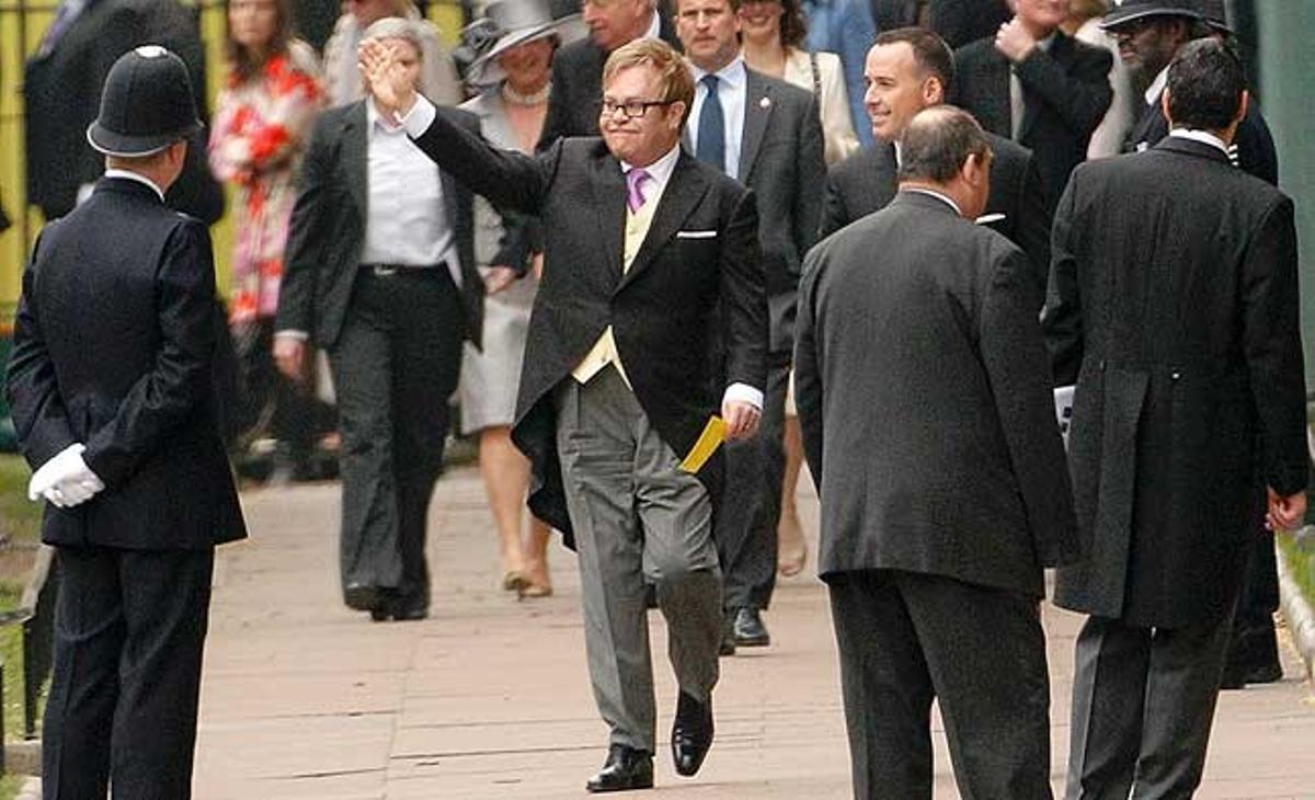 Elton John saluda a l’arribar a l’abadia de Westminster, amb el seu marit David Furnish.