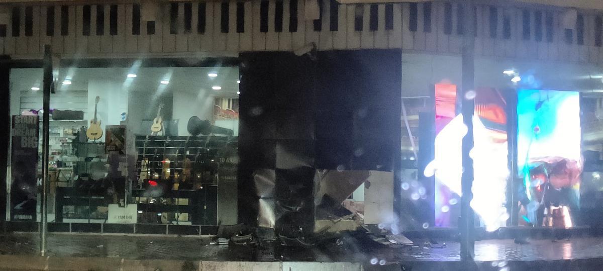 Estado en que quedó el escaparate de la tienda tras estrellarse el coche.