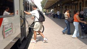Un viajero sube su bicicleta a un tren.