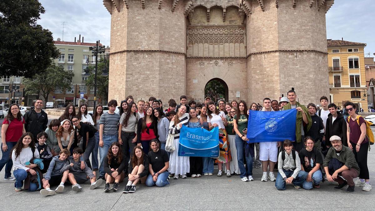 L' alumnat de Benimaclet, França i Bulgària, davant les Torres de Serrans amb el logo de l'Erasmus+.