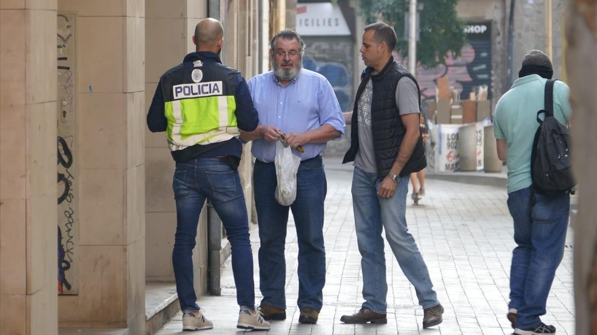 Victor Terradellas, presidente de Catmón, junto a dos agentes en la sede de Ciutat Vella, durante un registro en el 2018.