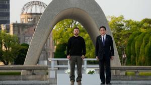 El primer ministro de Japón, Fumio Kishida (derecha), y el presidente de Ucrania, Volodymyr Zelensky, abandonan el cenotafio para las víctimas de la bomba atómica después de colocar ofrendas florales en el Parque Conmemorativo de la Paz de Hiroshima, luego de la Cumbre de Líderes del G7 en Hiroshima el 21 de mayo de 2023. (Foto de Eugene Hoshiko / PISCINA / AFP)