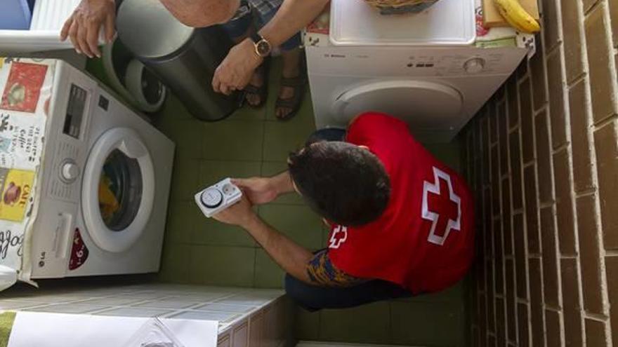Un técnico de Cruz Roja comprueba el consumo energético de un hogar.