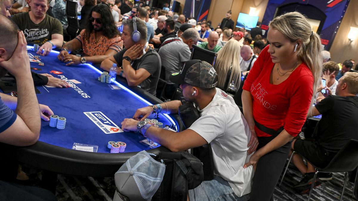 Una masajista trabaja sobre la espalda de un jugador de póker en el Casino de Barcelona. 