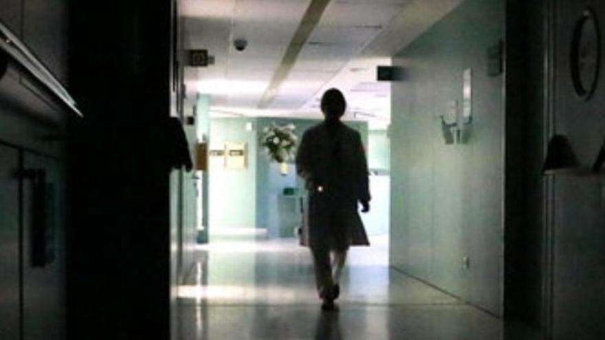 Una infermera caminant amb una llanterna en un passadís a les fosques