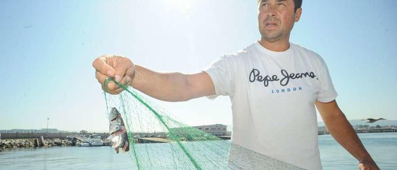 Un pescador del &quot;xeito&quot; sujetando una de sus redes. // Iñaki Abella