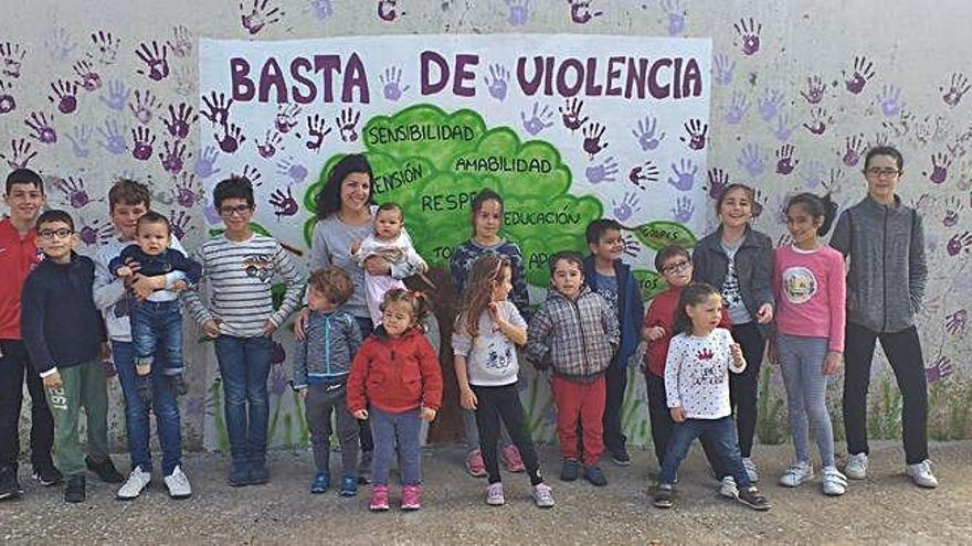 Niñas y niños de Cañizal ante el mural pintado en por ellos mismos en la pared de la escuela.