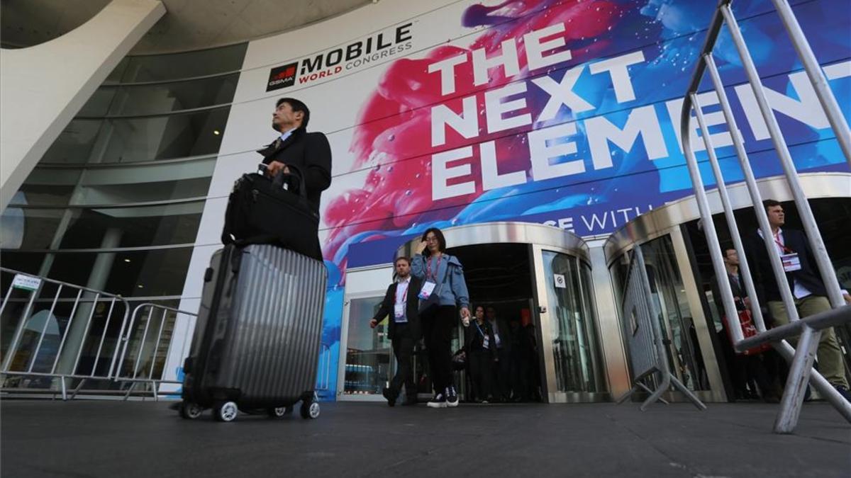 Asistentes salen con maletas del Mobile World Congress del 2017.