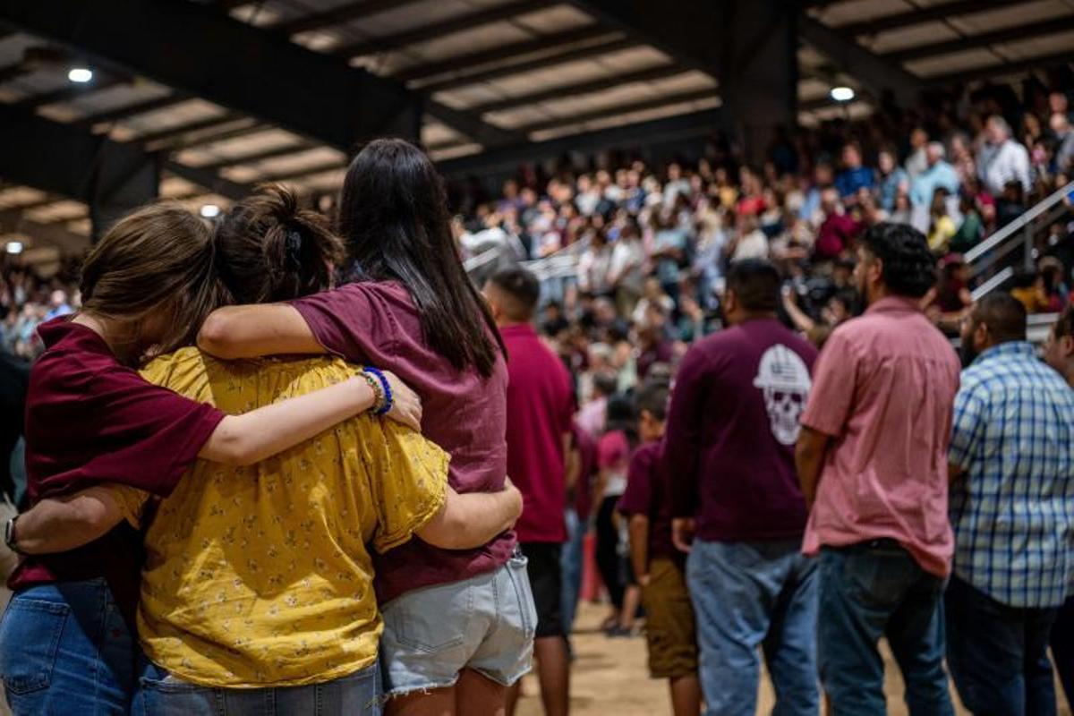 Miembros de la comunidad se abrazan en una vigilia por las 21 víctimas del tiroteo masivo en la Escuela Primaria Rob el 25 de mayo de 2022 en Uvalde, Texas. 