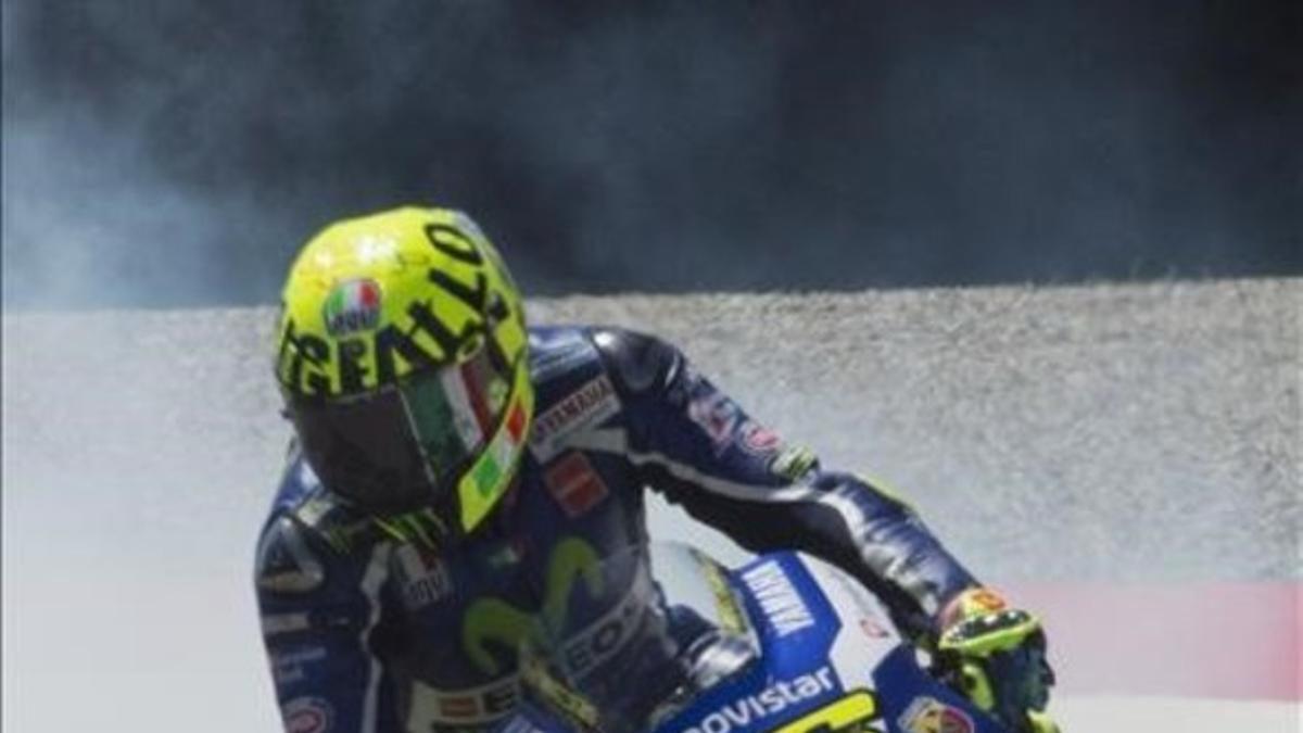 Valentino Rossi se retira mientras su motor escupe humo blanco.