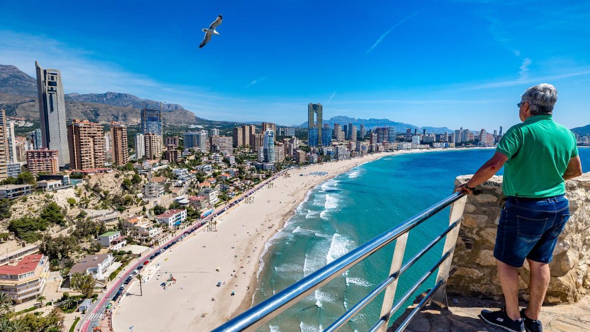 Un jubilado observa la playa de Levante de Benidorm desde el Castillo