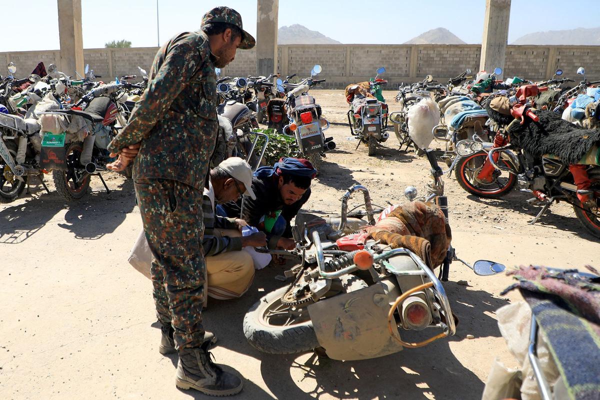 Los yemeníes se reúnen en medio de motocicletas mientras esperan que se les expidan licencias para conducir como parte de una campaña de seguridad de las autoridades huzíes, en Yemen