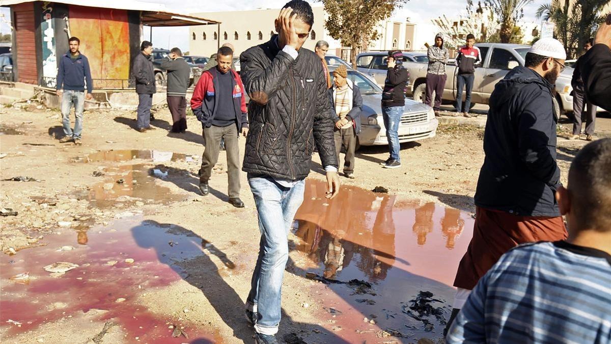 Ciudadanos libios comprueban los daños en el lugar del atentado, en Bengazi, el 24 de enero.