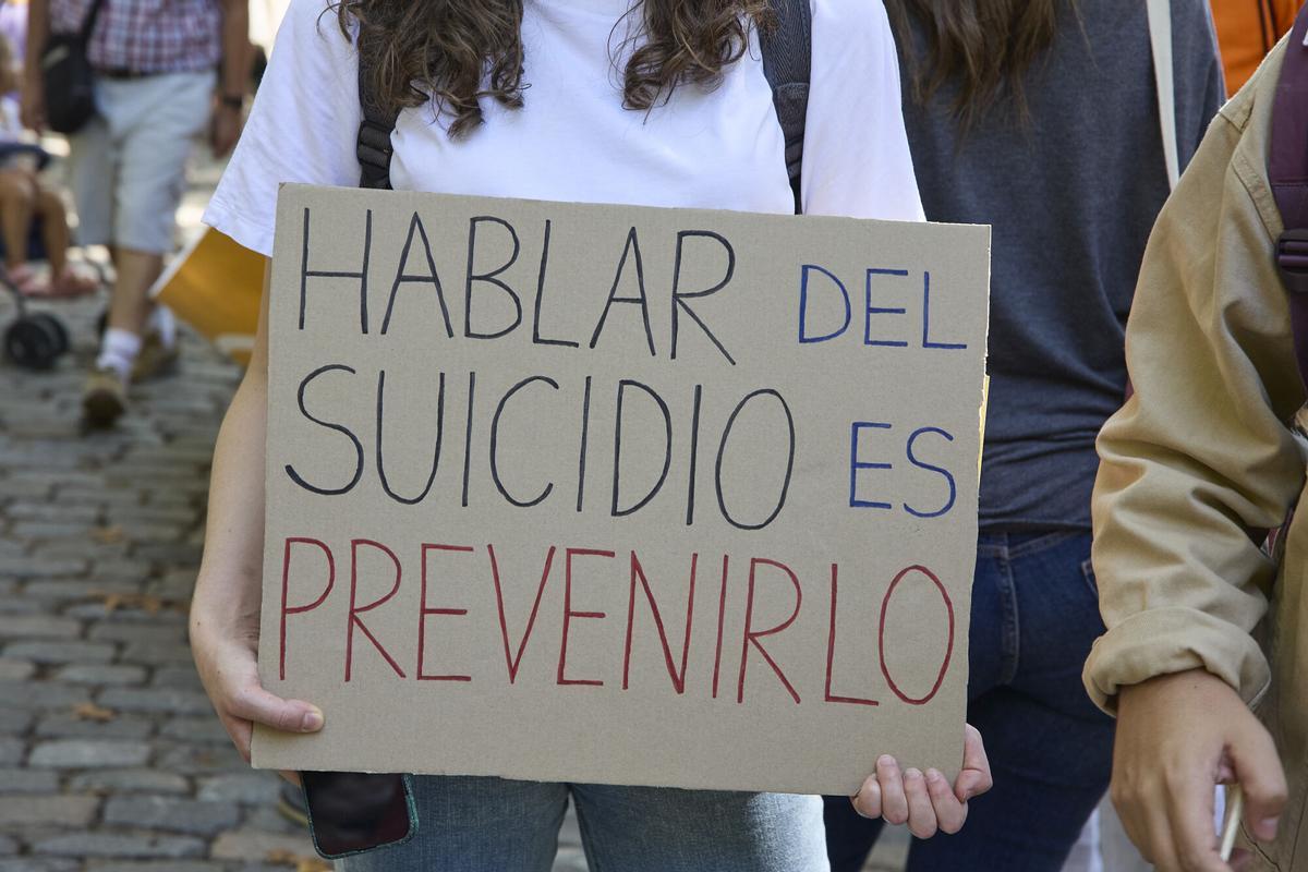 Una persona muestra una pancarta que reza 'Hablar de suicidio es prevenirlo.