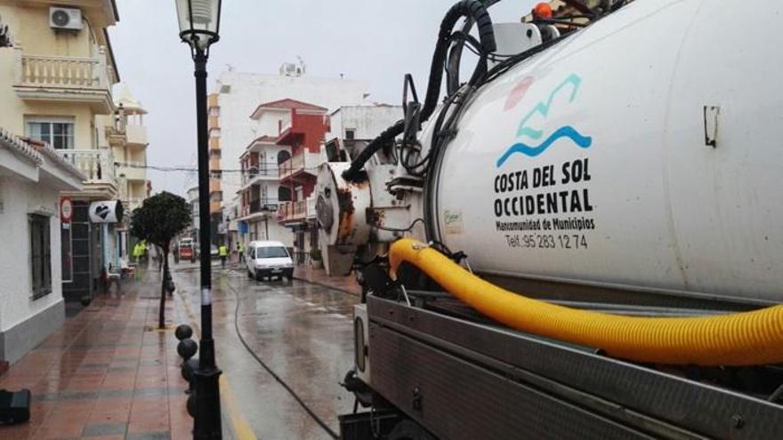 Operarios de Acosol realizan labores de limpieza en una calle de la Costa del Sol.