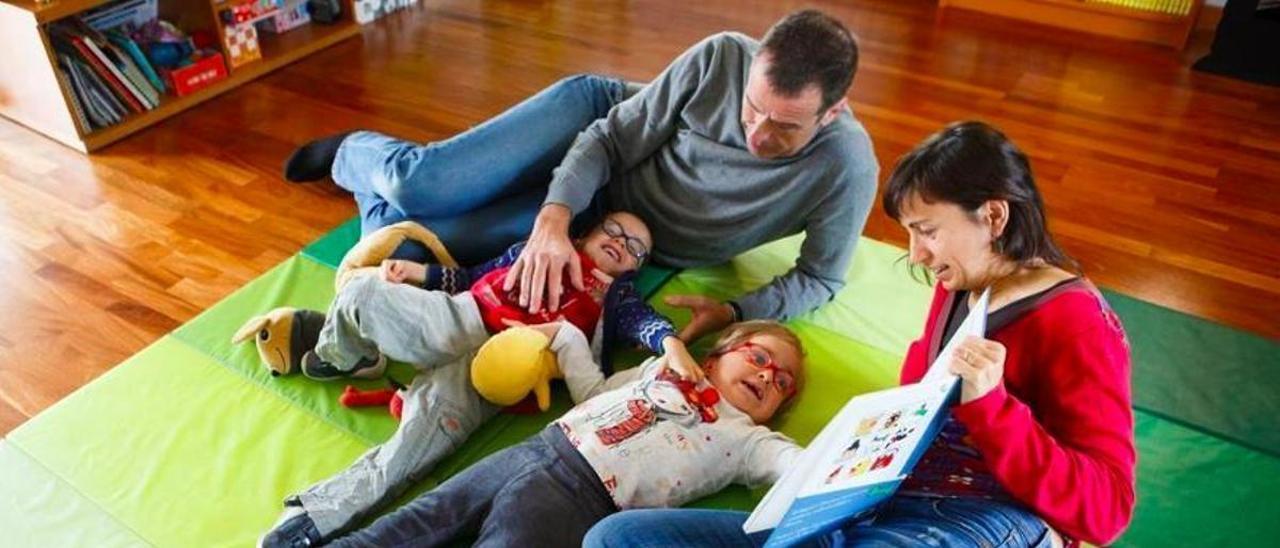 Miquel y Andrea, gemelos que tienen Parkinson, en su casa con sus padres Laura y Andreu.