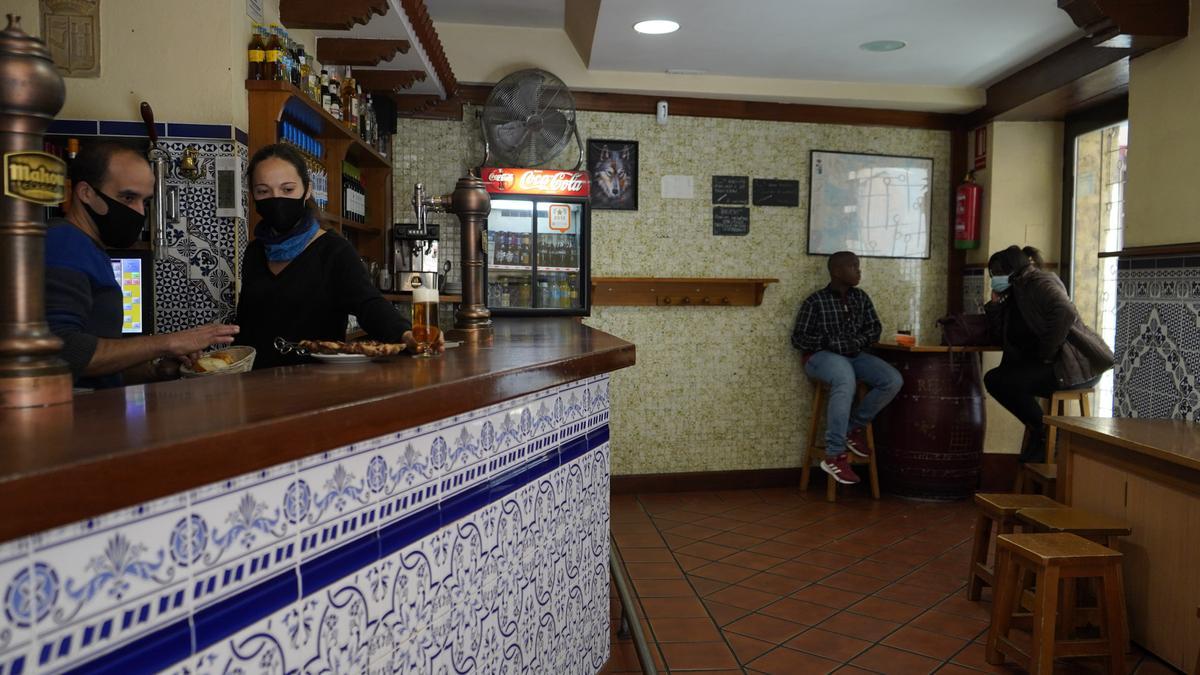 Clientes en una mesa en el interior de un bar de la capital.