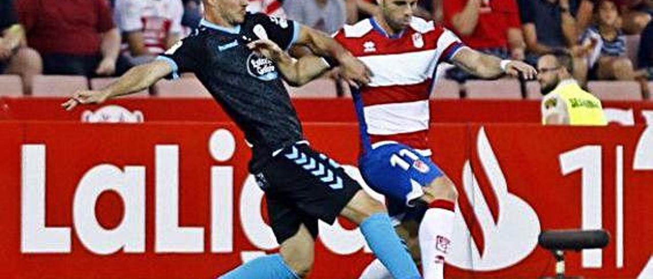 Rodri, delantero del Granada, pugna con un jugador del Lugo en el partido entre ambos equipos en Los Cármenes este curso.