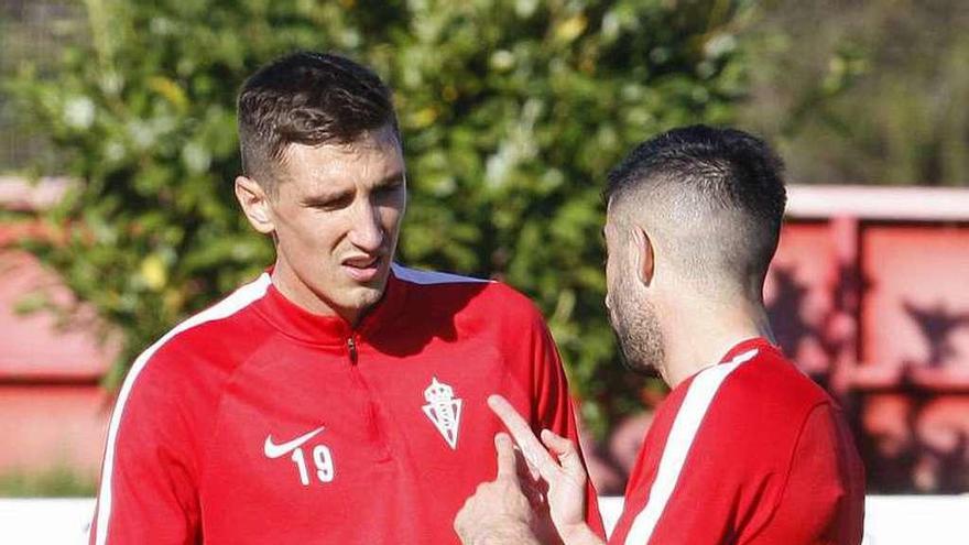 Scepovic y Santos dialogan durante el entrenamiento de ayer.