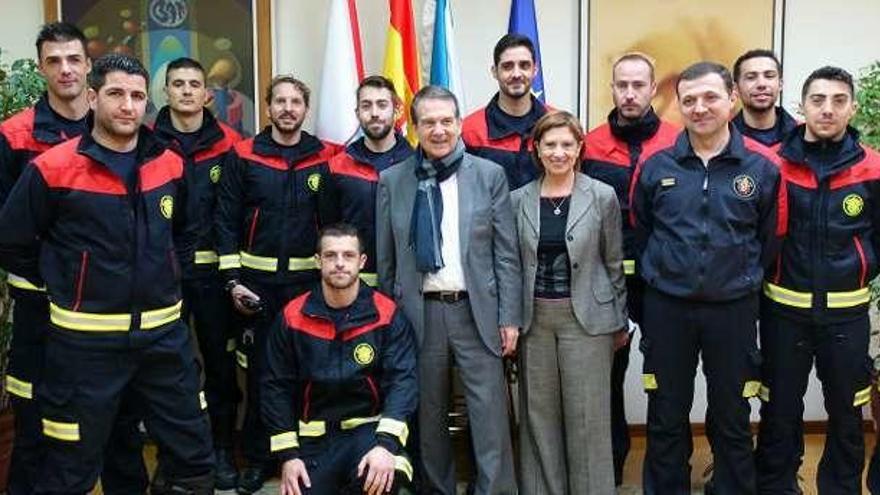 Abel Caballero y Elena Espinosa, con los doce nuevos bomberos que se unen al servicio municipal. // FdV